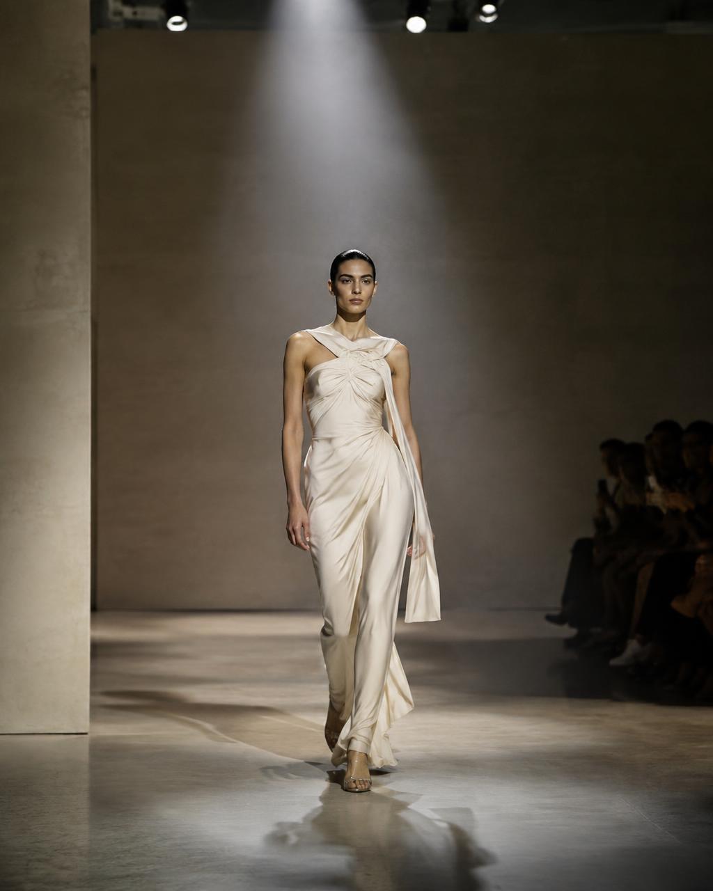Model in an ivory gown on a minimalist runway