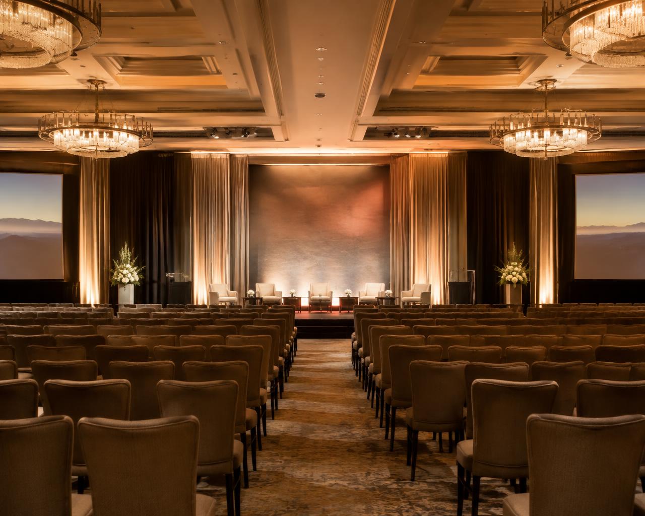 Candlelit hotel ballroom set for a private summit