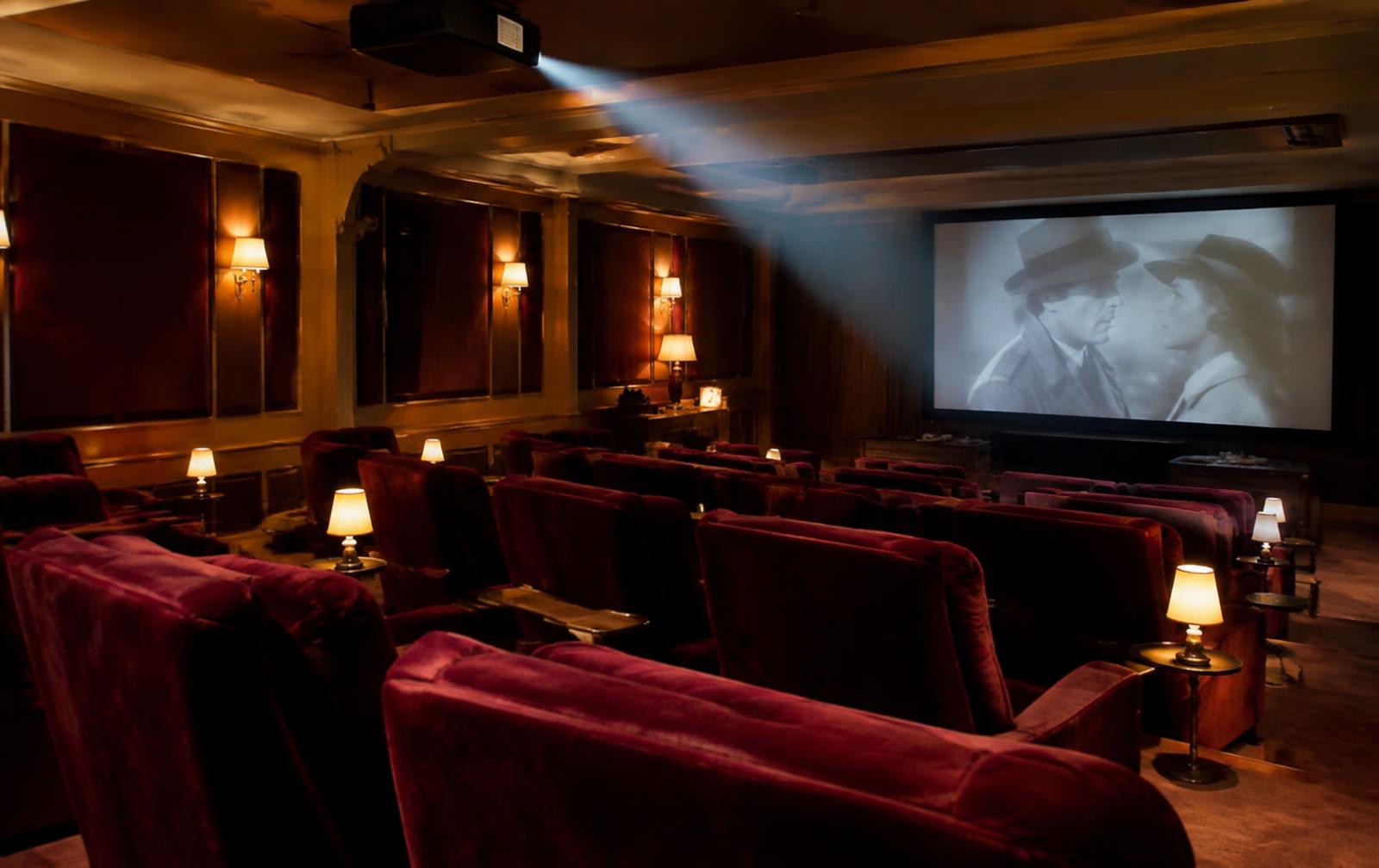 Private screening room with velvet seats and a projector beam